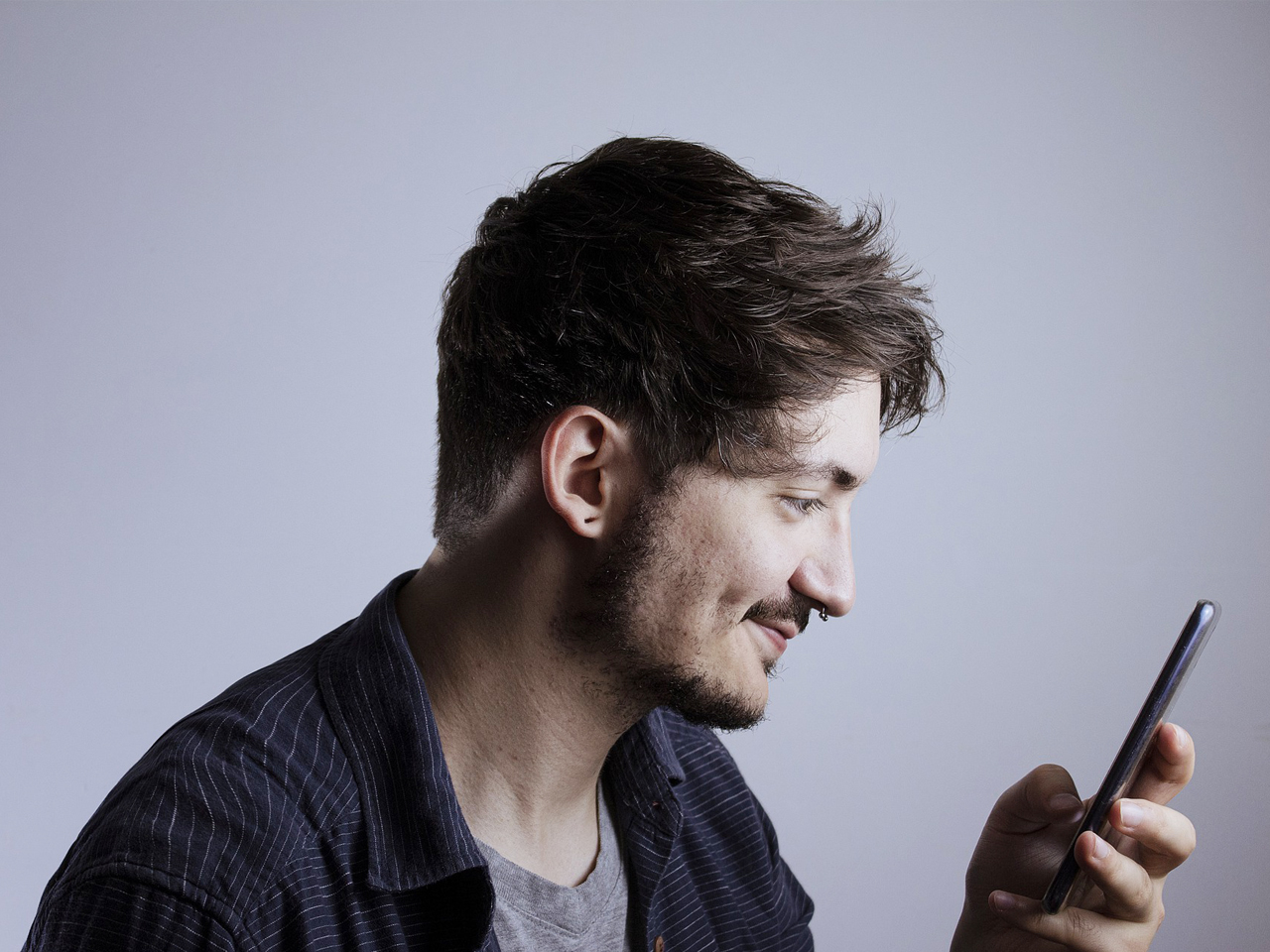 Young man smiling at smartphone