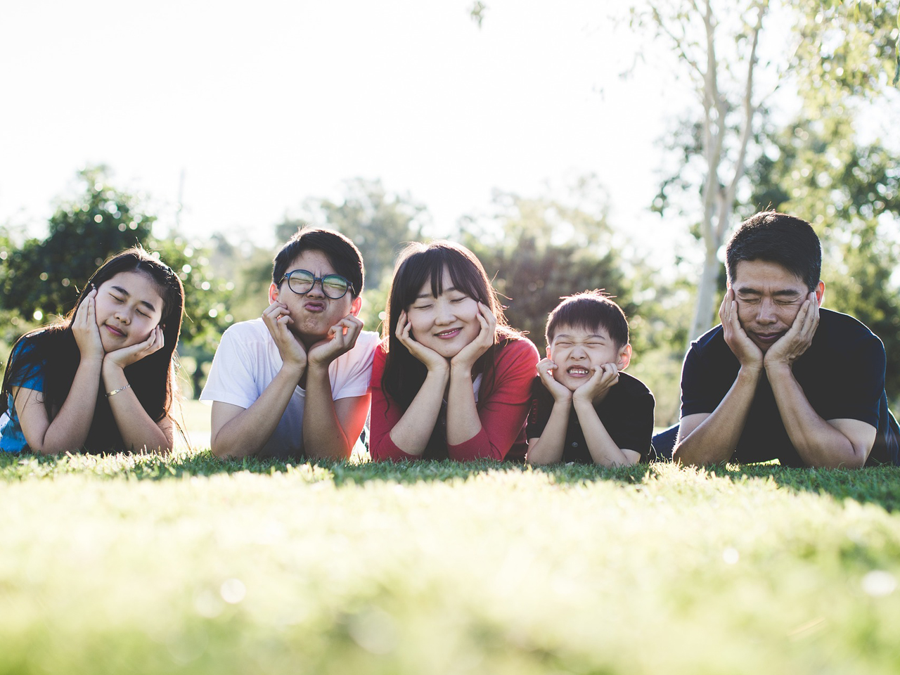 Family of 5 smiling in the grass